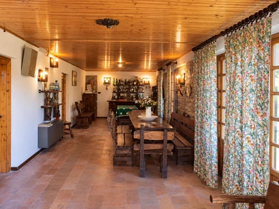 A long wooden table in a dining room filled with daylight
