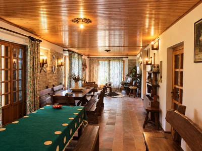 A dining room with a wooden table, chairs and a timber ceiling
